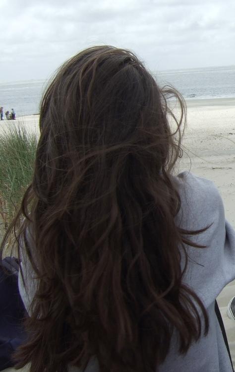 messy dark brown curls on the beach