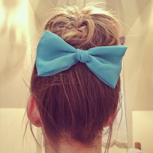 messy hair in a bun with a bow